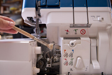 the foreman dusts off the overlock sewing machine