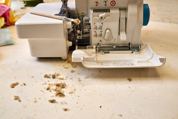 the foreman dusts off the overlock sewing machine