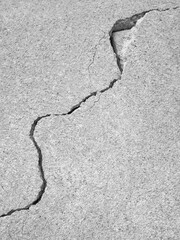 Obraz premium Crack on old plastering wall. Big long curve winding diagonal ascending, Fracture, Fissure, Split, Break, Cleft. Copy space. Black and white photo. Selective focus.