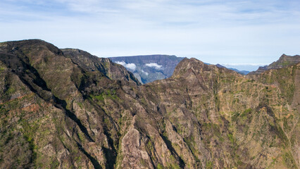 Majestic mountain ranges rise beneath a clear blue sky, showcasing nature's artistry in a remote landscape at midday