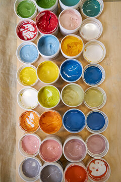 view from above of colorful jars with glazes and engobes