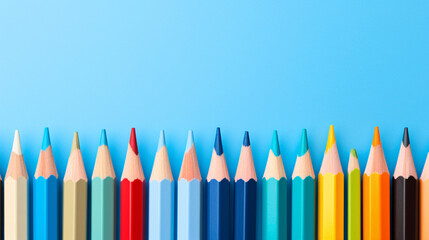 Multicolour pencils line the bottom edge of a blue background with clean space above for text.

