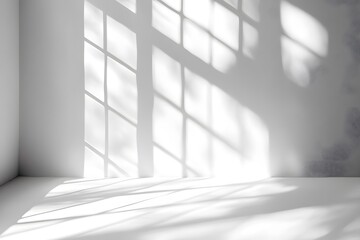 Obraz premium Soft sunlight casting intricate shadows of a window frame on a clean white wall, creating a calm and minimalist ambiance
