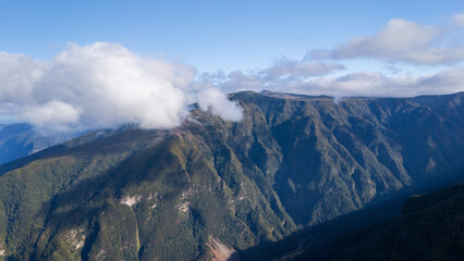 Majestic mountain peaks bathed in sunlight revealing vast landscapes and rolling clouds over a peaceful wilderness