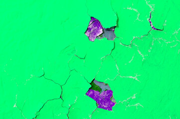 Peeling paint of green and purple colors on the stone texture background, peeling paint pattern