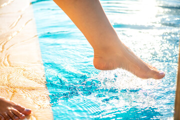 Woman's Leg Splashing Pool Water at Sunset