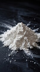 Fine white powder arranged on a dark surface showcasing its texture and detail under natural light