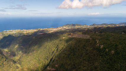 Stunning aerial view captures lush greenery and coastal beauty as morning light casts shadows across vibrant landscapes