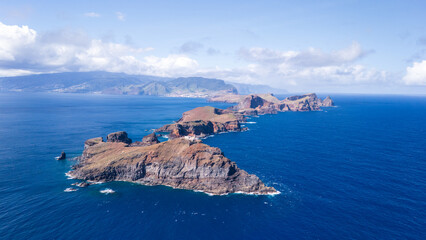 Mystical coastal landscape at the edge of the ocean showcasing rugged cliffs and vibrant blue waters in early daylight