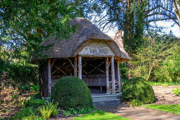 pretty thatched gazebo summer house in an English garden
