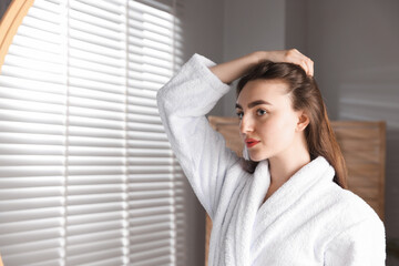 Naklejka premium Beautiful woman with healthy hair roots at home. Space for text