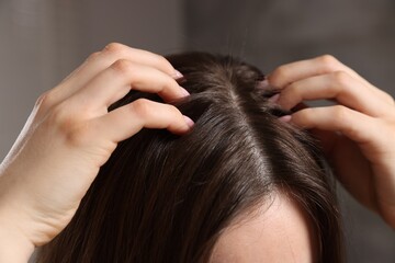 Naklejka premium Woman with healthy hair roots on blurred background, closeup