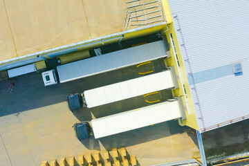 Trucks with trucks leave hangar of the warehouse of the shopping center.