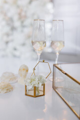 A glass box with wedding rings and fresh flowers at the wedding exit ceremony.