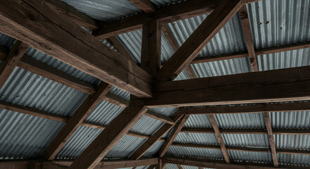 Obraz premium Rustic Interior View Of Weathered Wooden Beams And Corrugated Metal Roof