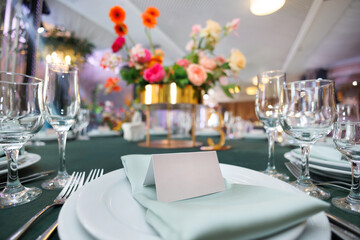 Elegant table setting with a blank card for the name of the guest at the wedding banquet.
