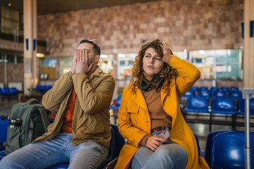 bored man and woman couple or friends wait train on the station