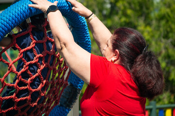 Instructor securing climbing net for children at playground