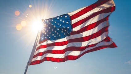 The American flag flutters proudly against the backdrop of a bright, clear sky on Independence Day. Sunlight creates a radiant effect, symbolizing freedom and national pride