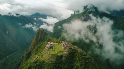 Aerial perspective of Machu Picchu and the ancient Incan ruins surrounded by verdant mountains and a cloudy sky in Peru