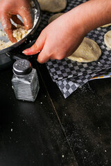 Close-up image showcasing hands taking arepa (colombian food) dough from pot with utensils, portraying culinary preparation.