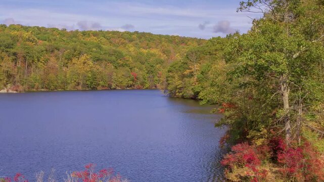 This 4K drone footage features Canopus Lake in Kent, NY, with the lake surrounded by autumn foliage and cloudy weather creating a serene atmosphere.
