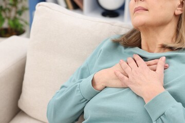 Heart attack. Senior woman suffering from pain in chest indoors, closeup