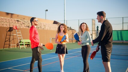 Young adults teaching and learning how to play pickleball