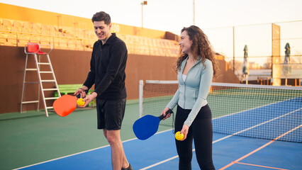 Young adults teaching and learning how to play pickleball