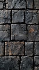 Fototapeta premium Rustic Stone Wall Texture: a detailed close-up showcases the rough, weathered texture of a solid, dark stone wall, evoking a sense of history and enduring strength.
