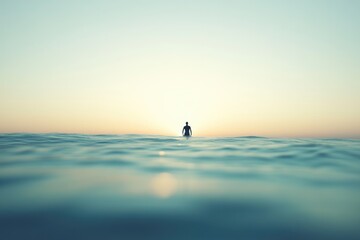 Fototapeta premium Solitary figure in tranquil ocean waters at sunset, peaceful and serene.