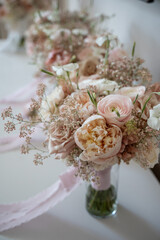 Blush and ivory flower bouquet in glass vase with ribbon