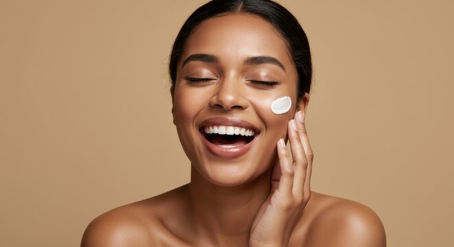 A radiant woman with eye patches smiles brightly showing her teeth against a neutral colored backdrop