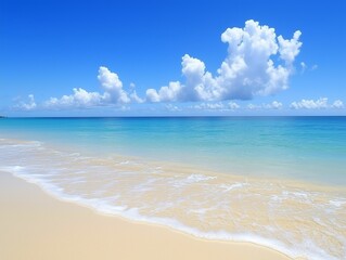 Fototapeta premium Gentle waves softly wash ashore on a pristine sandy beach. The vibrant blue ocean glistens under a clear sky; clouds drift lazily overhead, creating a peaceful atmosphere.