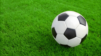 Fototapeta premium close up view of soccer ball resting on vibrant green grass, evoking sense of playfulness and excitement in game