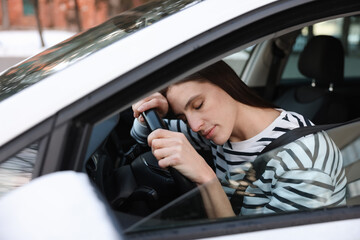 Tired driver sleeping on steering wheel in car, view from outside