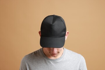 Man in stylish baseball cap on beige background. Mockup for design