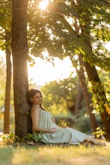 Tissu par mètre  Beautiful brunette pregnant woman walks in the park at sunset in summer  © Tina kids photo