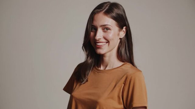 Attractive young woman with long brown hair wearing a casual brown t-shirt, posing and smiling against a white background, turning her head and body in different positions