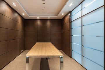 The empty space of a small modern office. The walls are decorated with dark wood panels.