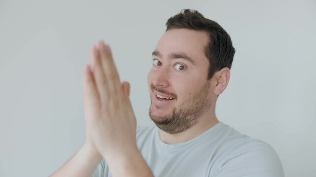 Smirking man rubbing his hands together with a mischievous expression