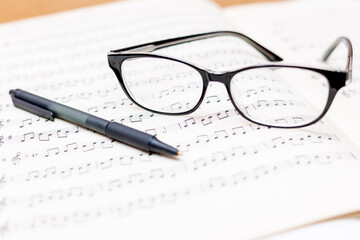Glasses and pen on sheet music