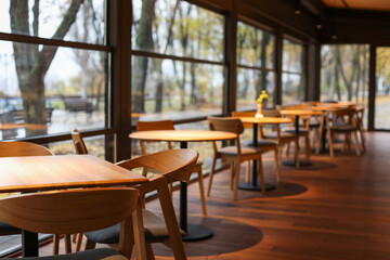 Stylish cafe with large windows and comfortable furniture. Interior design