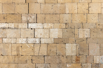 Front view of a natural shell rock stone brick wall, background texture