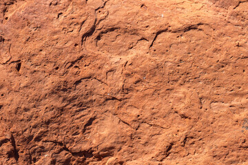 A detailed close-up photo of an old red brick with a rugged texture