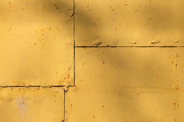 Yellow painted metal panels with rust and welding seams, industrial texture