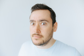 Obraz premium Man with wide eyes shows surprise in a light, casual setting