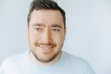 Fototapeta premium Smiling man with light beard and casual shirt against simple background