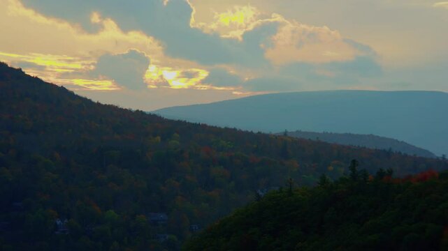This drone footage captures the Catskill Mountains near Kaaterskill Falls in New York, offering a breathtaking scenic view during the golden hour at sunset.