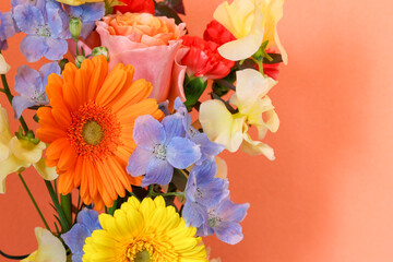 オレンジ色の壁背景の様々な花のブーケ